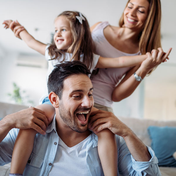 family of three playing on couch