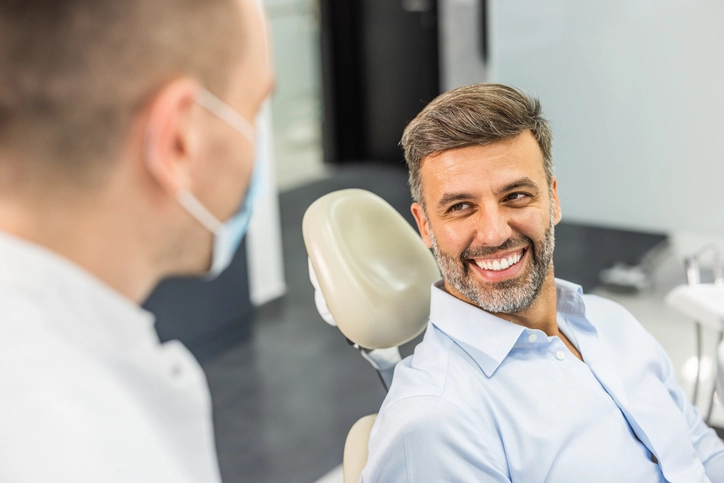 Patient in a dental chair smiling while consulting about dental implants in Fenton, MO