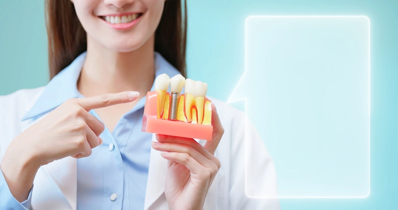 A dentist holding and pointing at a dental model in Fenton, MO