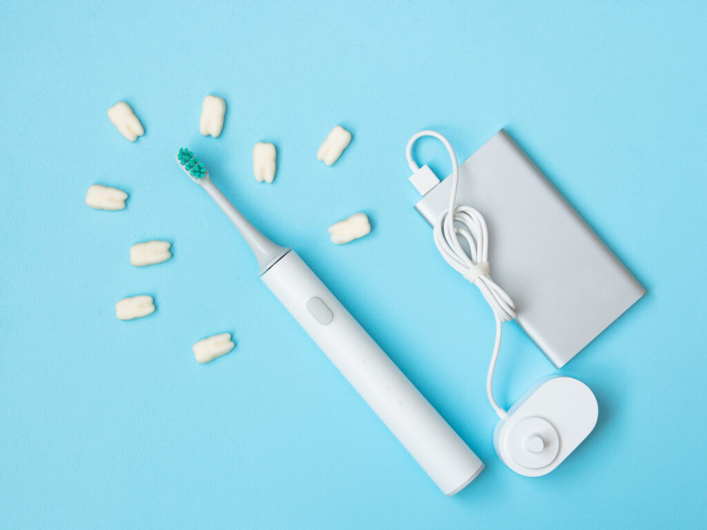 Smart electric toothbrush. Charges through powerbank and is controlled by the application on the smartphone. Modern technology for health. Healthy teeth. Dentistry. Medical robot.