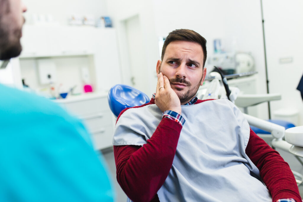Young good looking man having dental treatment at dentist's office.