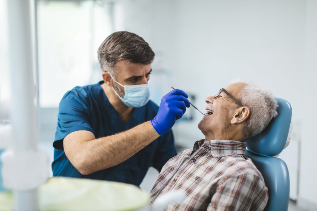 Young dentist giving his senior patient a routine checkup